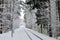 Railway in the middle of a fabulous snow-covered forest among trees and pines in winter