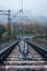 Railway in the mountains. Railroad tracks in autumn mountains. Railroad in foggy morning landscape. Transportation industry