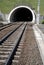 Railway and railroad track is goint into dark and long tunnel.