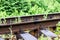 Railway rails with bolt mounting closeup against green grass in