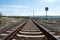 Railway rails with electric poles and in the background of the mountain