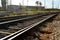 Railway, rails, sleepers and industrial buildings on a bright sunny day