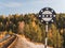 Railway sign Beginning of a dangerous place on the background of rails and autumn forest. Black circle with white dots