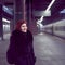 Railway station. Beautiful girl is standing on platform and waiting for train. Woman travels light