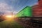 Railway station with cargo wagons in motion at sunset