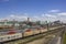 Railway station with a lot of multi-colored trains with cars on the background of modern buildings of the city, aerial view