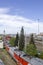 Railway station with a lot of rail tracks and the composition of the train with cars on the background of the city, aerial view