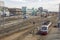 Railway station with a lot of rail tracks with modern and old trains and cars on the background of the city, aerial view