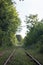 Railway station with nature and trees. Industrial landscape with the railroad, blue sky, and vegetation in summer. Railway