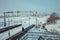 Railway station platform in the snow and a lonely walking passenger