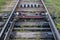 Railway switchboard with electric drive and red rod fixed on resinous sleepers with bolts, with chipping barin black and white.