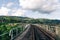 Railway track on the bridge on the background of a beautiful mountain landscape. Suburban railway on the background of the village