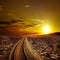 Railway track crossing drought desert under sunset sky