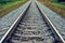 Railway track line going into distance, railroad train track with crushed stone, two parallel rails