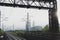 Railway tracks going into the fog, pipelines and chimneys in the haze