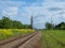 Railway tracks among yellow fields, country railroad