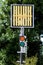 Railway trackside red and green traffic signal lights below signal sign mounted on metal pole at local train station