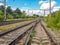 Railway traffic light and locomotive on railroad in distance. Mirage on railway track. Atmospheric landscape.