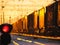 Railway traffic light shows blue signal on railway and railway with freight train as the background