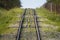 Railway for the trailer in the mountains at the fence, the mountains in the summer in the grass and forests, at the foot of the