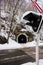 Railway tunnel in snowy forest with crossing sign and traffic lights foreground. Transport and railroad concept.