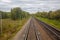 Railway. View from the window of the last train car or from the cab. Russian autumn landscape. Railway rails and sleepers