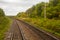 Railway. View from the window of the last train car or from the cab. Russian autumn landscape. Railway rails and sleepers