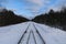 Railway in winter. Rails and sleepers - a road for locomotives and electric locomotive covered with snow.