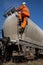 Railway Worker Climbing onto a Tanker Wagon