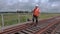 Railway worker on walkie talkie checking rails and walking away