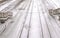 Railways in snow in train station among the stairs, top view.