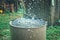 Rain barrel. Strong stream of water pours into an old metal barrel during heavy rain