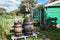 Rain barrels in front of a characteristic small green house on t