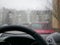 Rain behind the glass of a car. Rain droplets flow down the car glass. Rain behind the windshield of the car inside