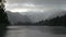 The rain and bright rays of morning sun over the Lake Matheson