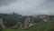 Rain clouds slowly cover the stony mountain slopes. the lush green of the local meadows slope of the Caucasus mountains.