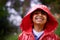 Rain, coat and portrait of boy in a forest for adventure, freedom or exploring games in nature. Winter, travel and face