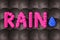Rain concept. Rain letters arranged of umbrella on dark background. Bad weather, nobody
