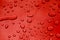 Rain drops on red car paint threated with hydrophobic coating