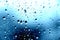 Rain. Drops on the window. Close on the glass. Shower. Wet glass. Blue background.