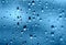 Rain. Drops on the window. Close on the glass. Shower. Wet glass. Blue background.