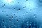 Rain. Drops on the window. Close on the glass. Shower. Wet glass. Blue background.