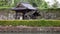 Rain falls on traditional Japanese wooden pavilion by stone castle walls