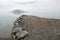 Rain and fog on the fjord, the pier and an small island in the mist, Norway