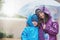 The rain never stopped us from having fun. Portrait of two siblings standing under an umbrella outside.