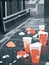 Rain pattering on the plastic bags and cups strewn about the street.. AI generation
