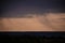 rain seen from afar at sunset. colored clouds on the horizon