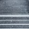 Rain splashes on gray granite steps of staircase