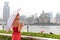 Rain umbrella Asian woman walking by Bund river Shanghai city enjoying walk on Asia China travel