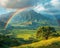 Rainbow appearing over a lush valley